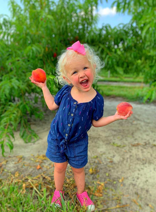 All smiles for this peachy young peach picker 